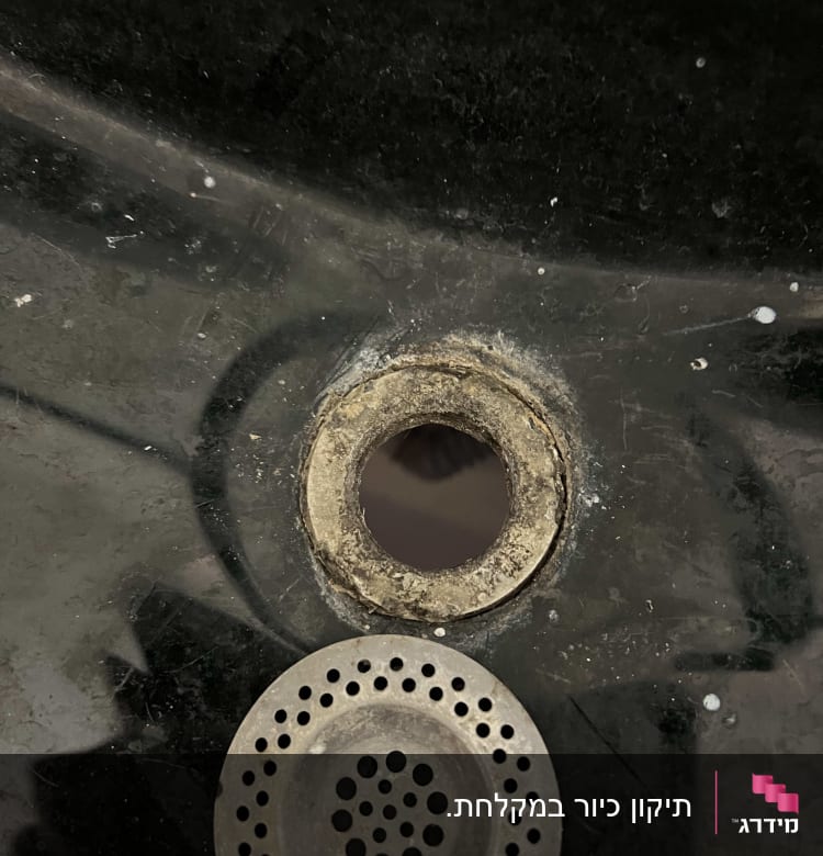 חור בכיור עם מסננת מתכת חלודה